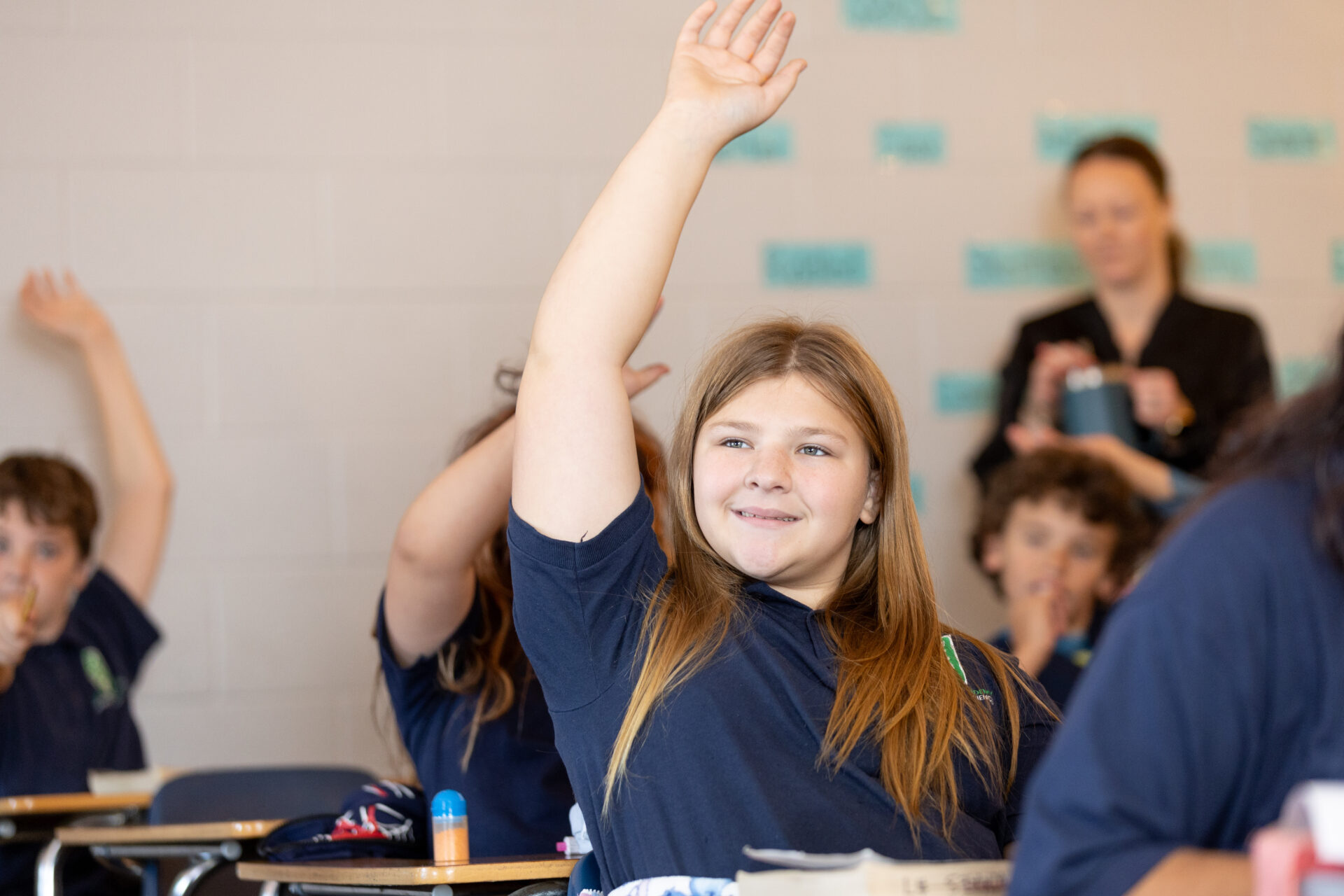 Students eagerly participating in a vibrant classroom, showcasing enthusiasm for learning and engagement.