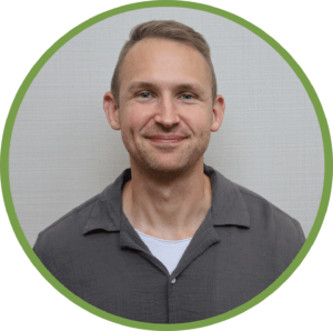 Smiling man in casual attire, showcasing warmth and approachability in a circular frame.