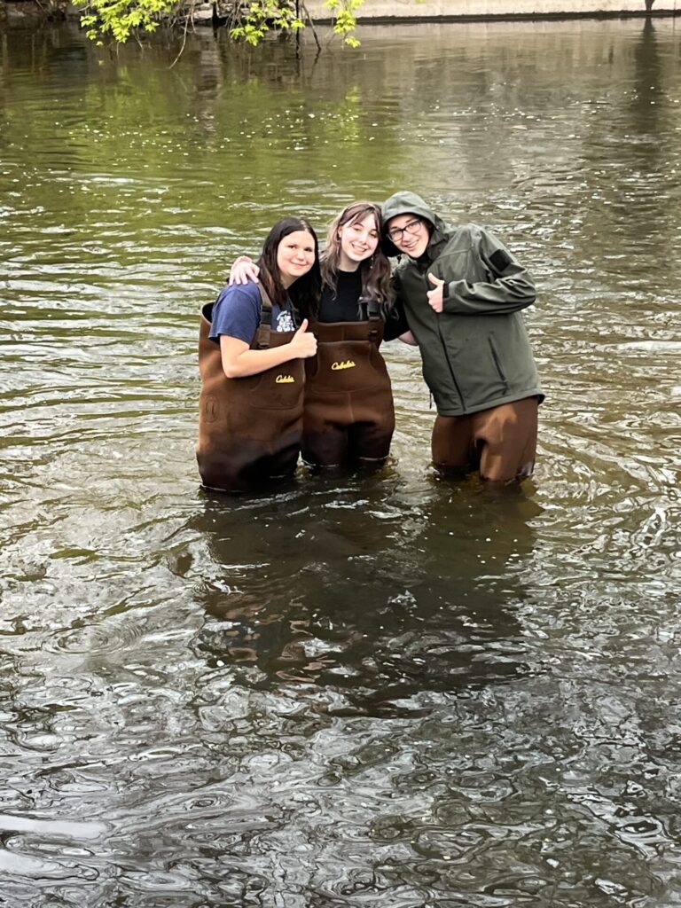 Friends enjoying a fun day by the river, dressed for adventure in nature.