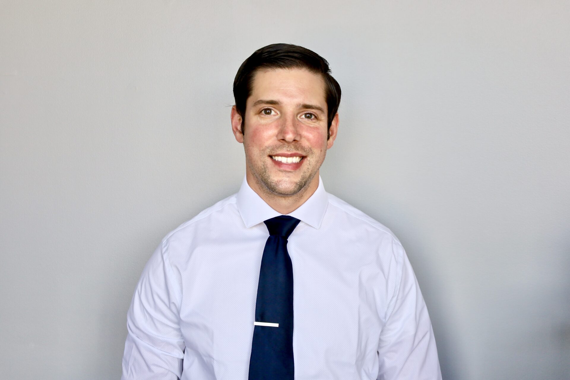 Professional portrait of Kevin Maitner in a crisp dress shirt and navy tie.