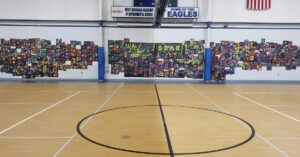 A wide picture of the West Michigan Academy of Environmental Science mural with Reggie Laurent and volunteers.
