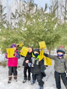 Young WMAES students holding up charts with animals.