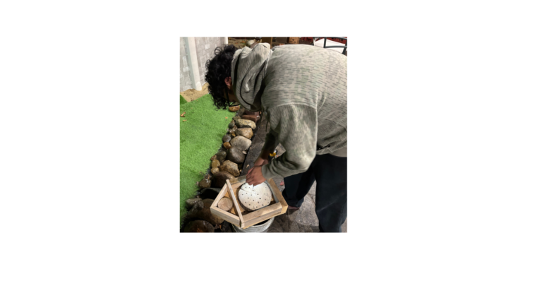 Person working on a wooden project amidst vibrant landscaping elements and serene lighting.